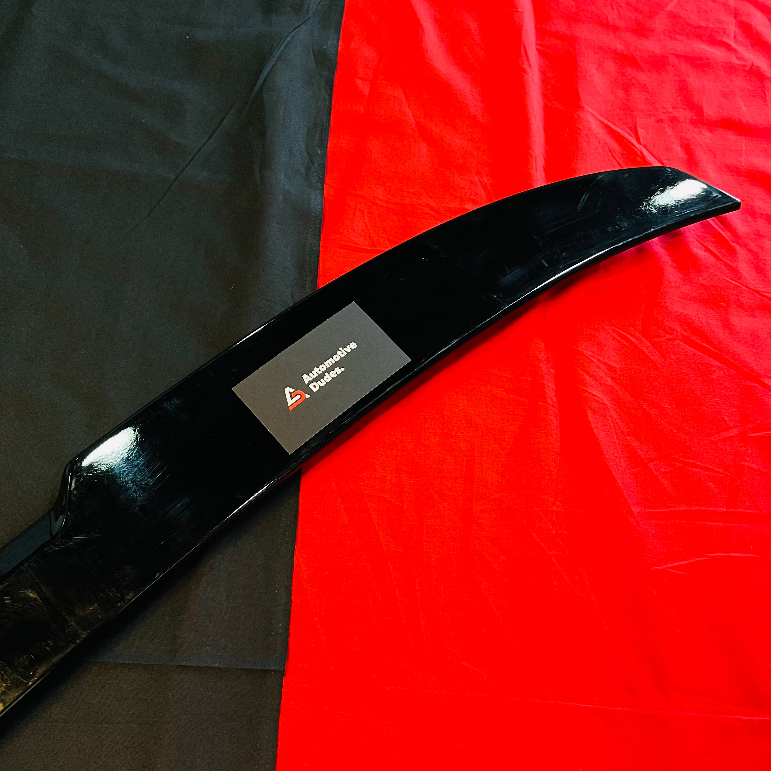 Black car spoiler with a brand label on a red and black background